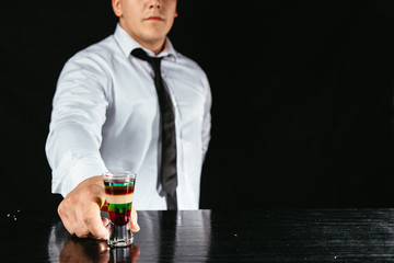 Bartender making a colorful alcohol shot.