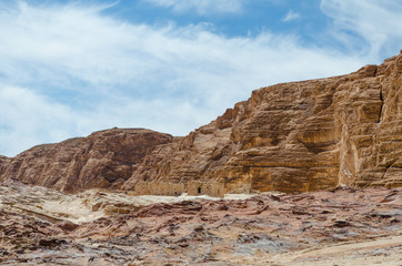 Fototapeta premium ruins of houses in the desert against the backdrop of high rocky mountains and blue sky with white clouds in Egypt Dahab South Sinai