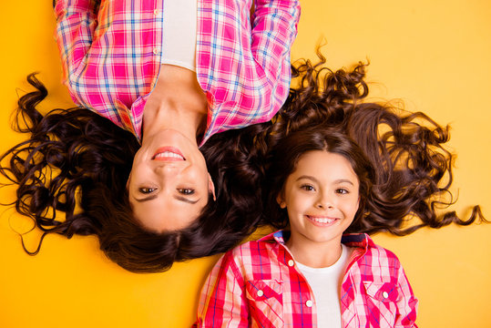 Close up top above high angle view photo beautiful she her models mom daughter adorable amazing long hair weekend lying floor wear casual pink plaid checkered shirts isolated yellow background