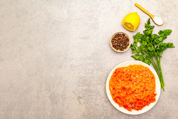 Raw minced red fish (stuffing) on a stone background. Ingredient for making fish-balls, casseroles, terrine, pate. Spices, salt, parsley, lemon. On a stone background, top view, copy space.