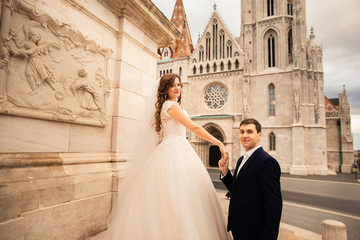 Obraz premium Young beautiful stylish pair of newlyweds by the Fisherman's Bastion in Budapest, Hungary