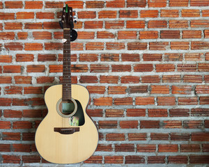 Obraz na płótnie Canvas Acoustic guitar with brick wall background