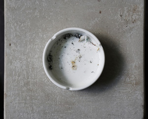 Cigarette in ashtray on wooden background.