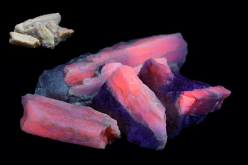 Crystals of major industrial lithium ore spodumene showing red fluorescence in ultraviolet light...
