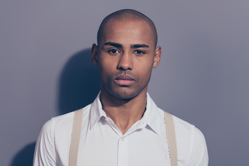 Close up photo beautiful amazing dark skin he him his man looking straight on camera kind sincere eyes shiny shaved face wearing white shirt pastel suspenders clothes isolated grey background