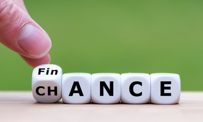 Symbol for a good finance chance. Hand turns a dice and changes the word "FINANCE" to "CHANCE".