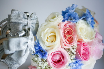 Two wedding rings on top of bridal bouquet