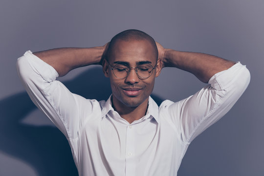 Close up photo amazing stunning dark skin he him his macho eyes closed arms hands behind head perfect good mood satisfied refreshed shaved face wear specs white shirt isolated grey background