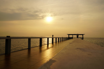 Wooded bridge in the port along sunrise at island beach.