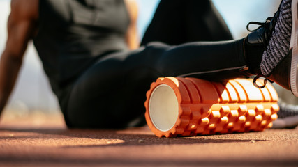 Man foam rolling. Athlete stretches using foam roller.