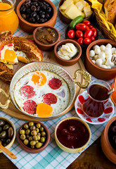 Traditional Turkish Breakfast with sesame bagel and fry egg with sausage.Used ceramic breakfast set and copper egg pan.