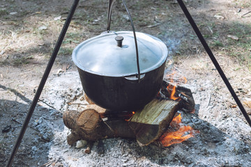 Hiking pot, Bowler in the bonfire. Fish soup boils in cauldron at the stake. Traveling, tourism,...