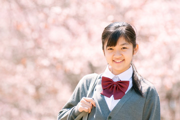 桜の前で微笑む中学生