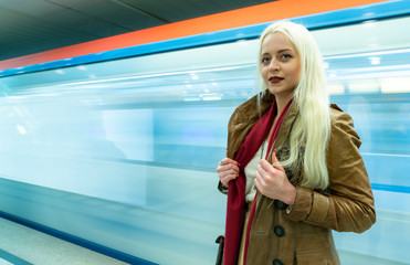 Obraz premium Beautiful young girl in the subway on a blurred background in train traffic