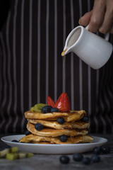 Chef pouring honey on pancakes