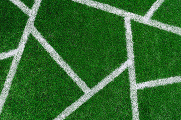 Fototapeta premium green grass on the football field with white non-parallel stripes on it