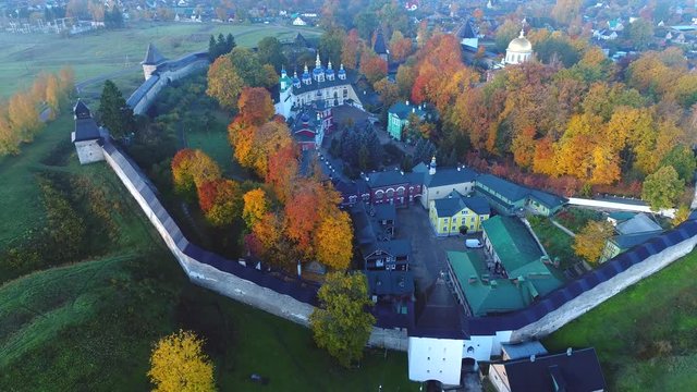 Flight over the Holy Dormition Pskovo-Pechersky monastery in October morning. Pechora, Russia