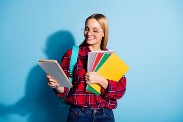 Portrait of her she nice-looking charming cute attractive cheerful cheery teen girl wearing checked shirt holding in hands copy-book note-book isolated on teal turquoise bright vivid shine background