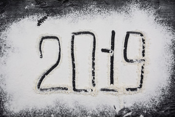 2019 new year inscription on flour on a wooden black background