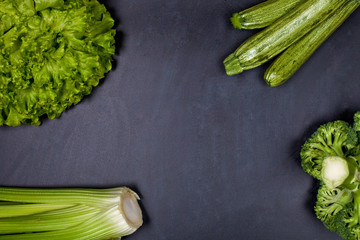 Green organic vegetables on blackboard background.