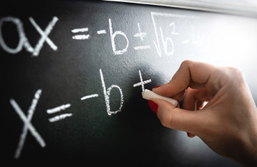 Math equation, function or calculation on chalkboard. Teacher writing on blackboard during lesson...
