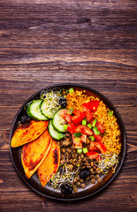 Groats with lentils and vegetables on wooden table
