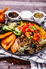 Groats with lentils and vegetables on wooden table