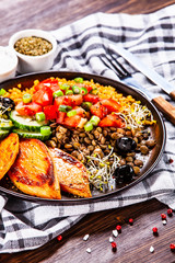 Groats with lentils and vegetables on wooden table