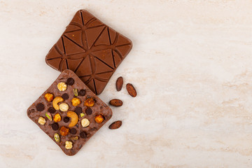 Top view of craft chocolate bars on beige marble background with copy space
