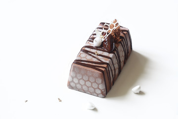 Contemporary Apple Chocolate Mousse Cake covered with white velvet spray and cocoa glaze, on white background.