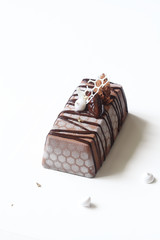 Contemporary Apple Chocolate Mousse Cake covered with white velvet spray and cocoa glaze, on white background.