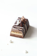 Contemporary Apple Chocolate Mousse Cake covered with white velvet spray and cocoa glaze, on white background.