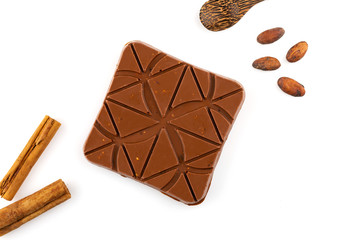 chocolate bar with cocoa beans and cinnamon sticks isolated on white