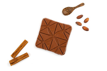 chocolate bar with cocoa beans and cinnamon sticks isolated on white