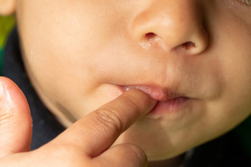 Closeup view of a young child with index finger in mouth