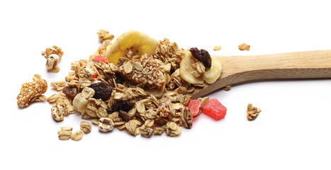 Crunchy tropical muesli pile mix with banana, pineapple, papaya slices and raisins with wooden...