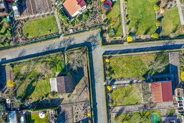 Vertical aerial view of an allotment garden with huts, garden and paths