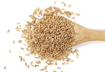 Peeled oat grains with wooden spoon isolated on white background