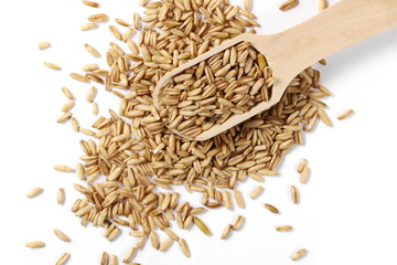 Peeled oat grains with wooden spoon isolated on white background