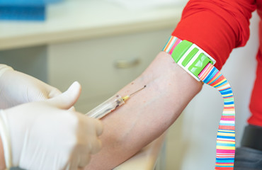 Young woman on the collection of blood in the hospital laboratory