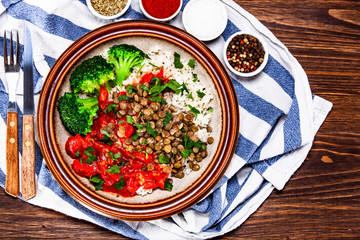 Rice with lentils and vegetables on wooden table