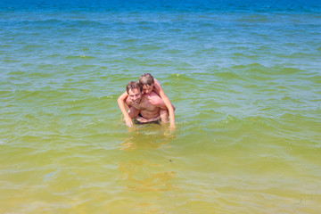 Father and son splashing in the sea