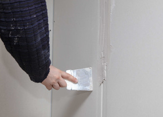 Worker aligns the walls with plaster. Repair in the house