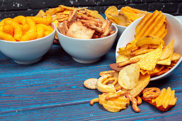 Differnt Types of Junk food, salty-sticks, salty-crackers on wooden table in still-life