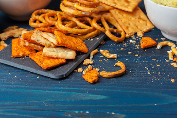 Scattered beer snacks assortment on blue wooden background