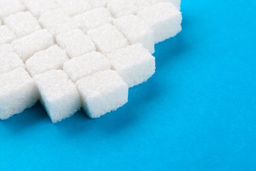White sugar cubes on a bright blue background