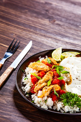 Grilled meat, white rice,fried egg vegetables on wooden table