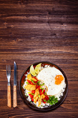 Grilled meat, white rice,fried egg vegetables on wooden table