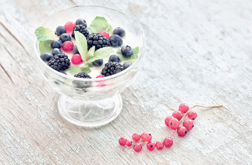 Summer light breakfast. Berries with yogurtmo and simple flowers. Vintage style.