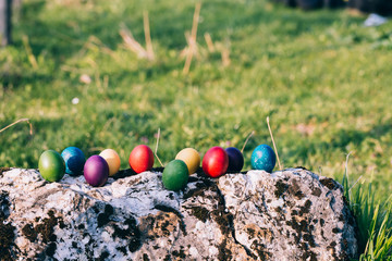 Colorful Easter egg on a rock in the nature.